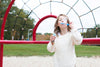girl blowing bubbles at park
