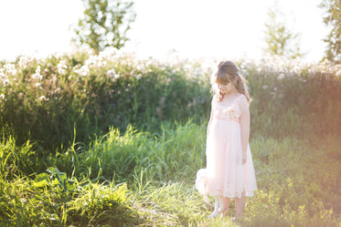 girl in pink looking down at grass