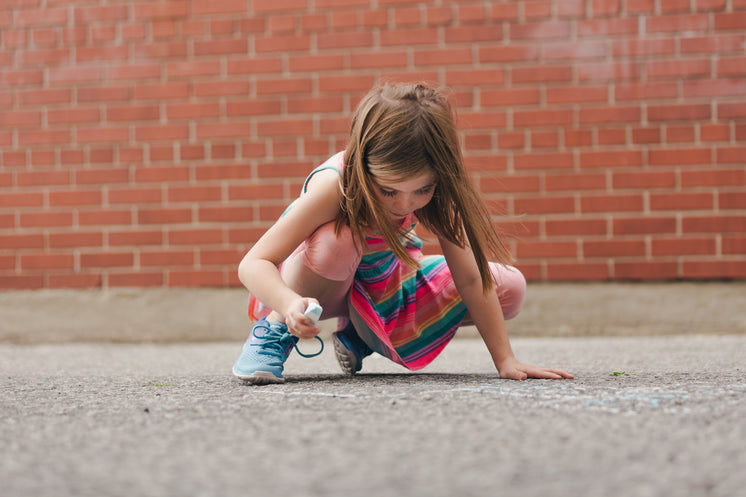 Girl Using Sidewalk Chalk In Schoolyard