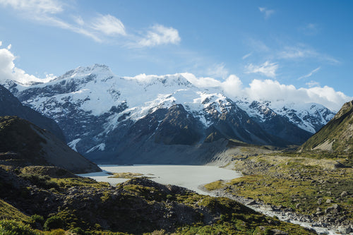 glacial lake below snow capped mountains