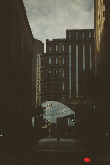 glass building at the end of a shadowed street