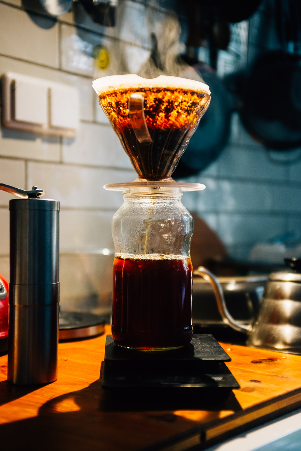 glass pour over coffee being brewed on wooden countertop