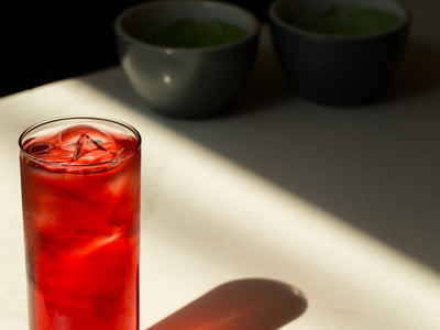 Glass With Iced Red Beverage Reflects On A White Table