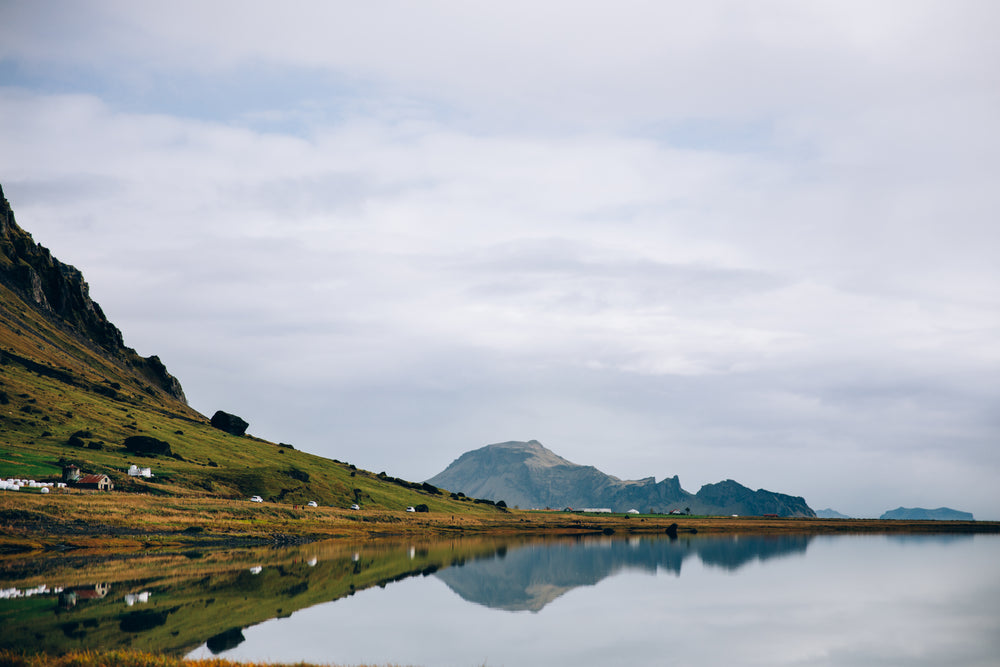 glassy iceland lake water reflects hillside