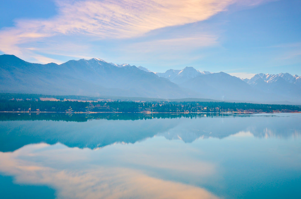 glassy lake reflects snow-capped mountains