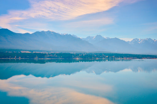 glassy lake reflects snow-capped mountains
