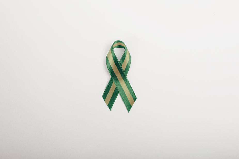 Green Ribbon On Color Background. Liver Cancer Concept Stock Photo