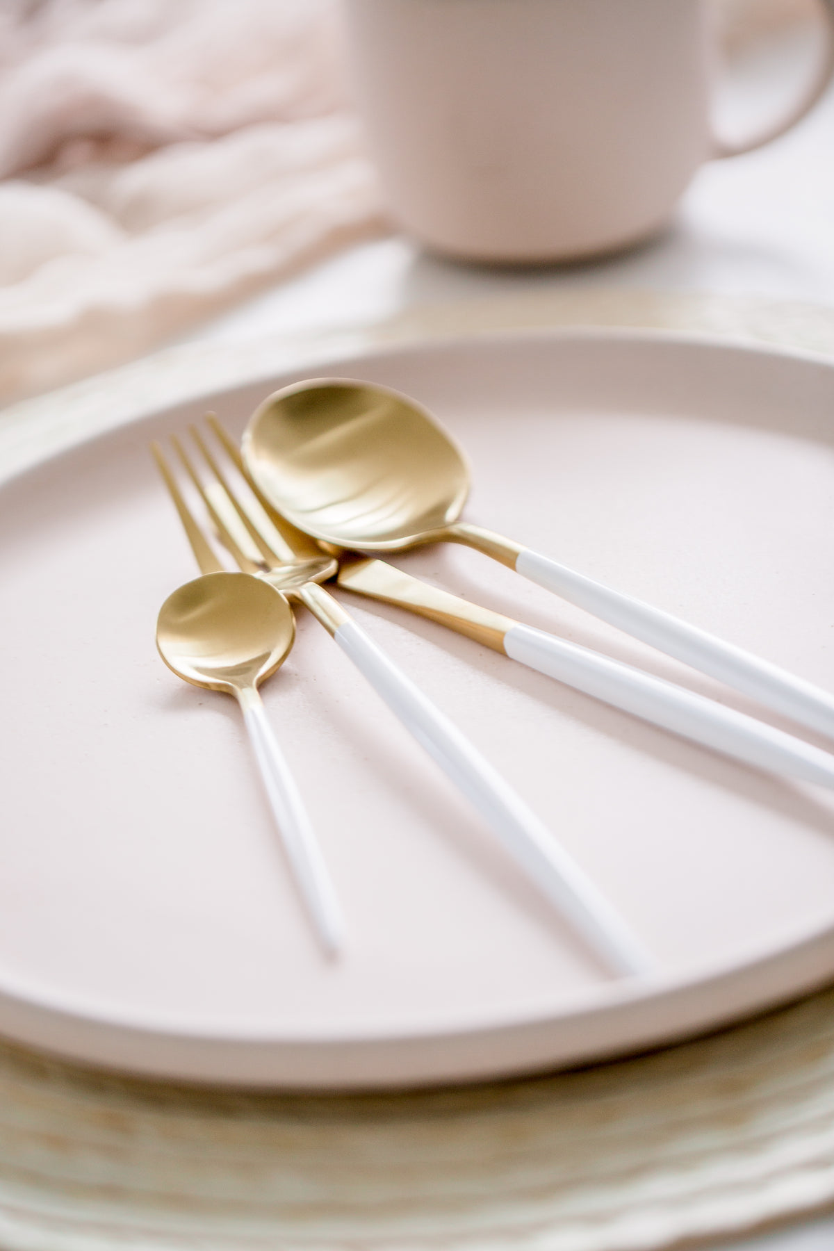 金色和白色餐具放在盘子上