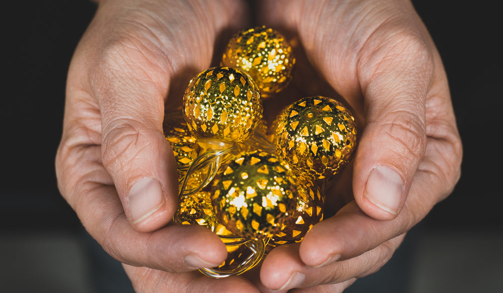 gold christmas lights held in hand