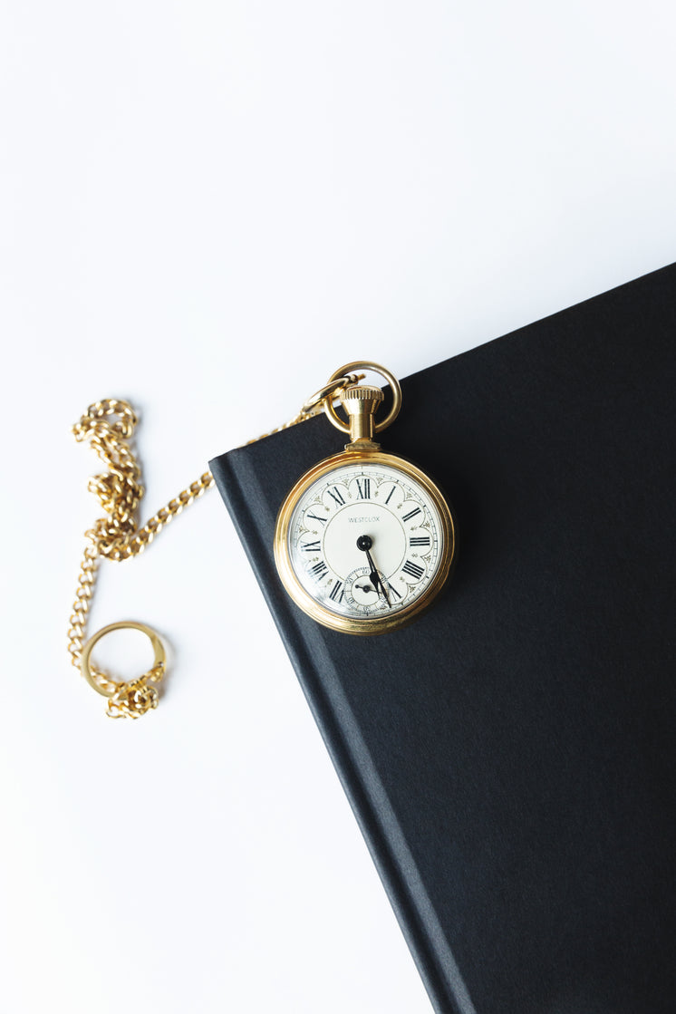 Gold Pocket Watch On A Black Notebook