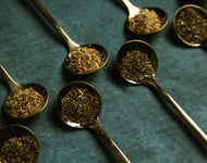 Gold Spoons In A Row Filled With Loose Leaf Tea