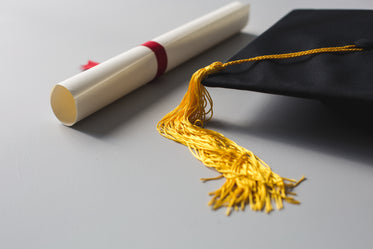 gold tassle graduation cap and diploma