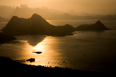 golden light on water surrounded by mountains