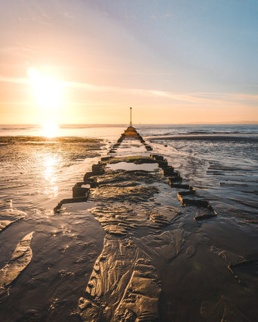 golden sunset over a broken pier