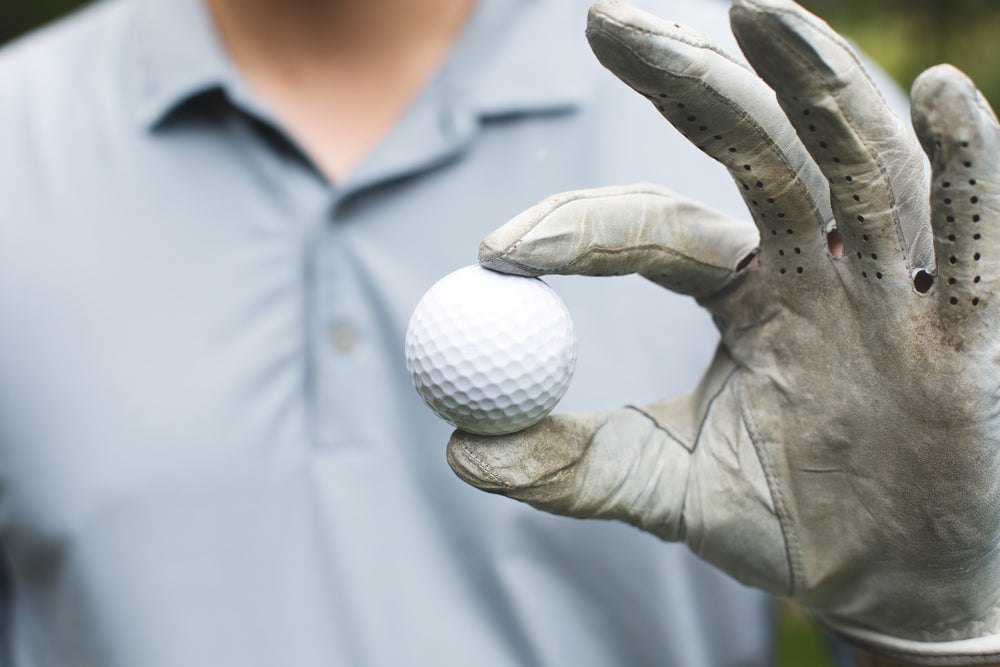 golfer holds golf ball