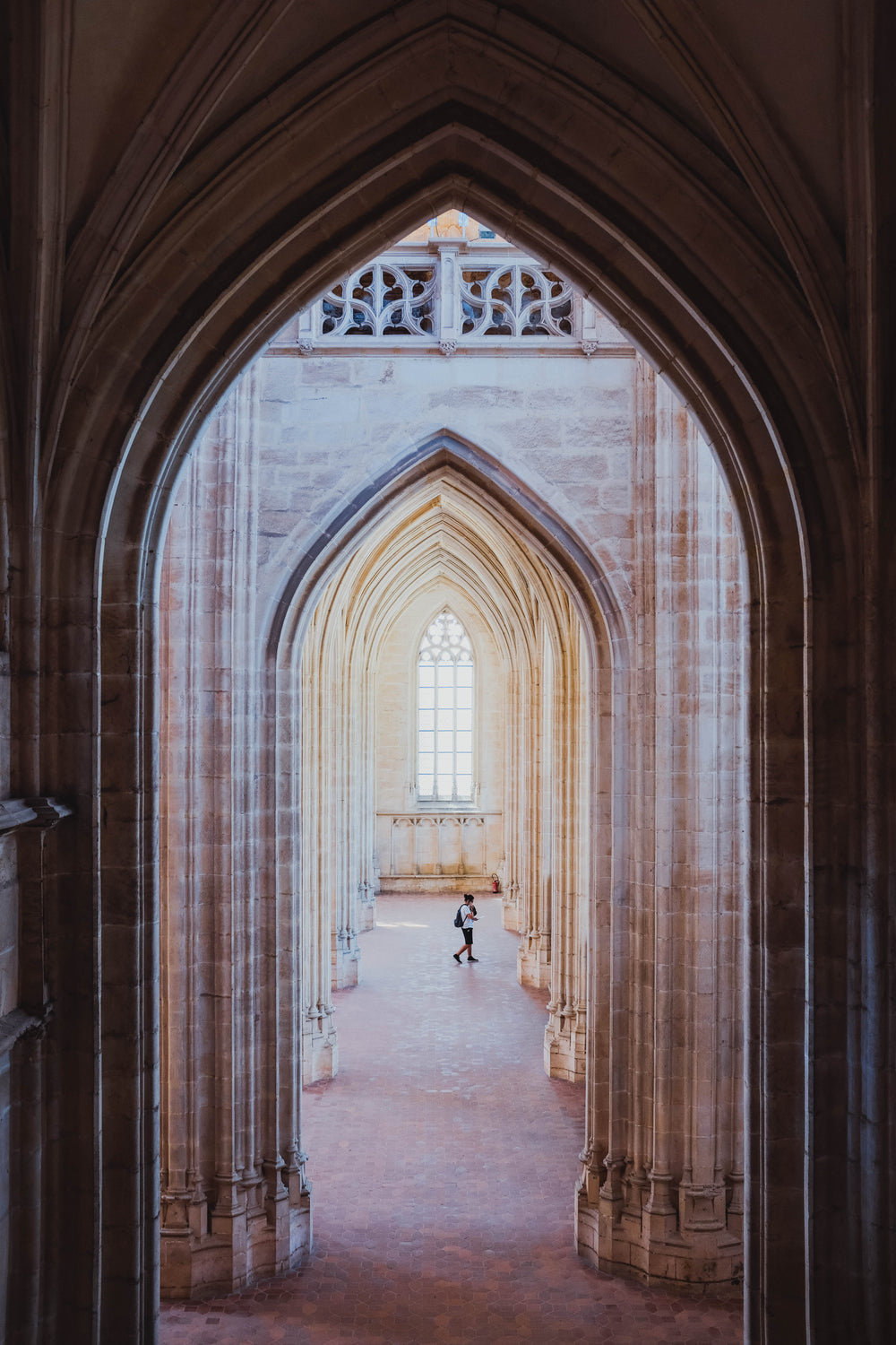 gothic archways in a corridor lead to a gothic window