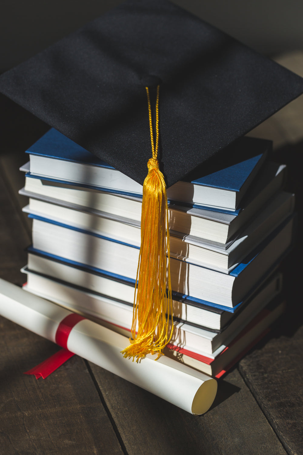 grad cap diploma and books