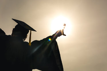 grad student celebrating diploma up in sun