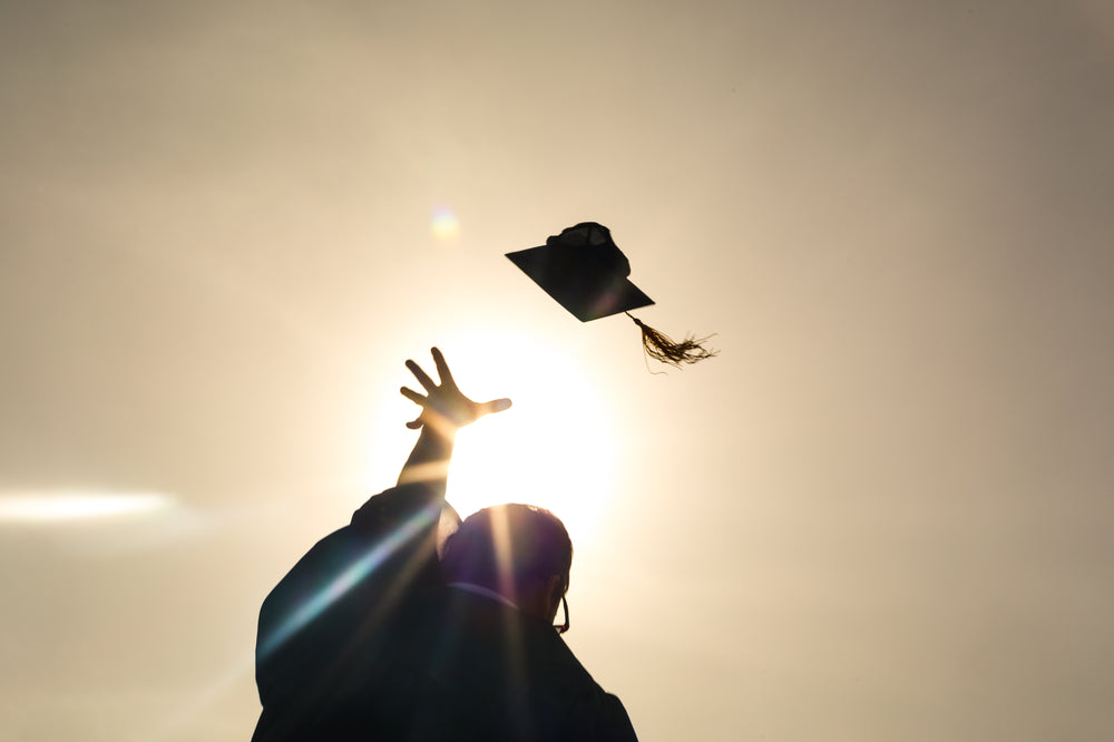 grad student throwing up cap