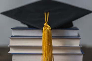 graduation cap gold tassle and books