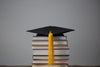 graduation cap on top of books