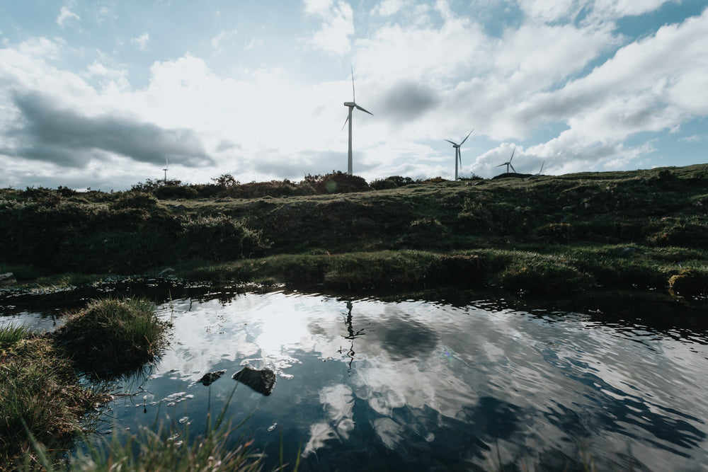 grassy hills with modern windmills