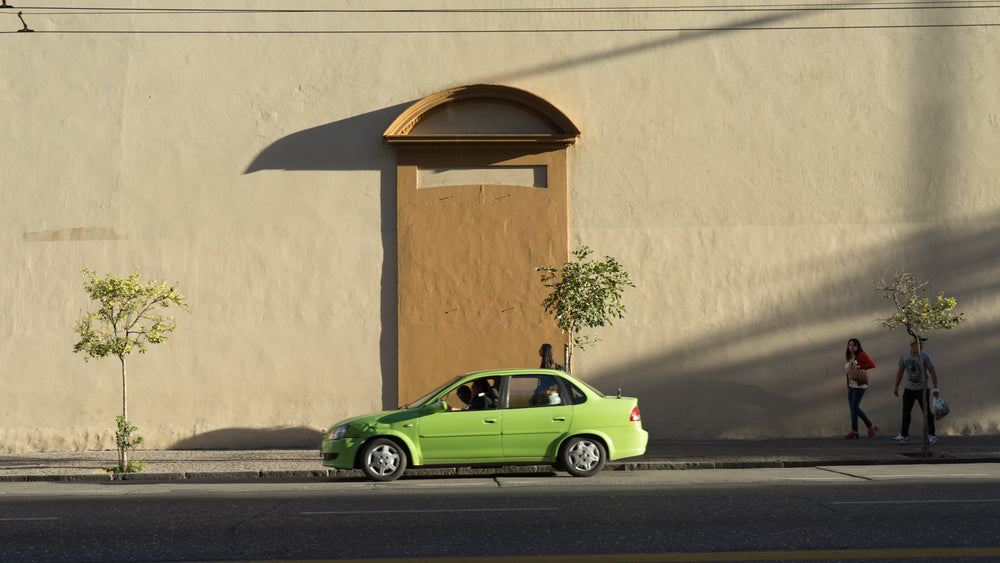 green car passes wall