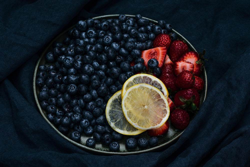 green plate filled with fruit in the middle of frame