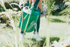green watering can pours water in garden