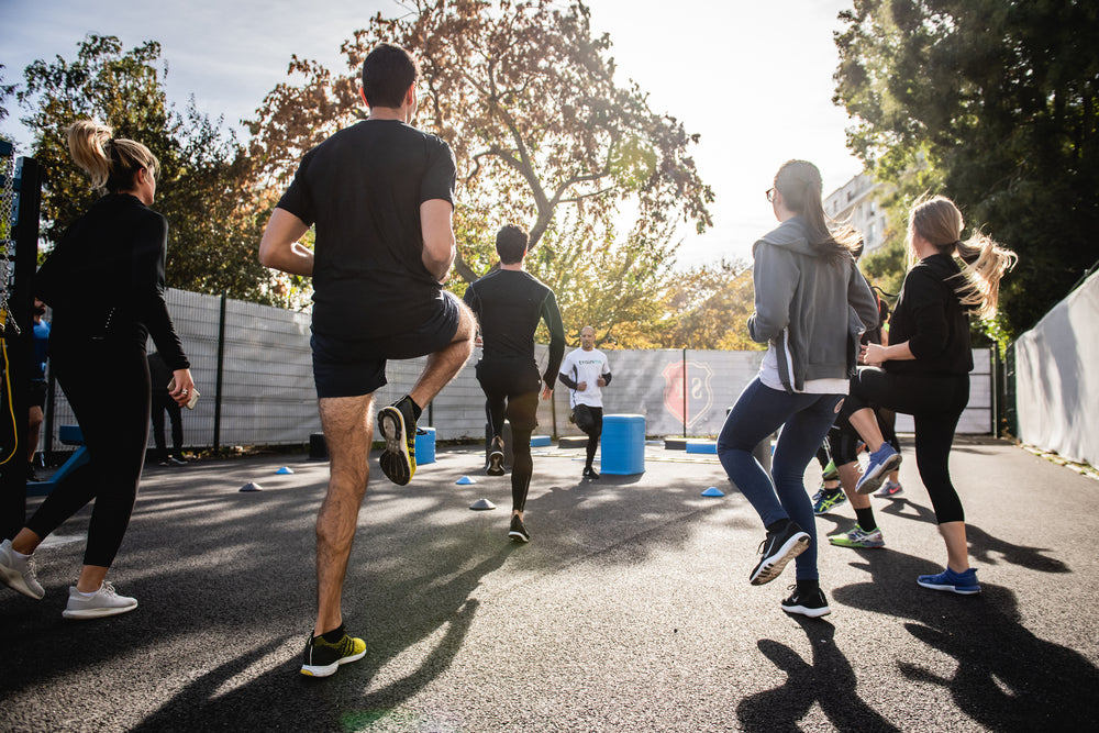 group of people stand facing a fitness instructor