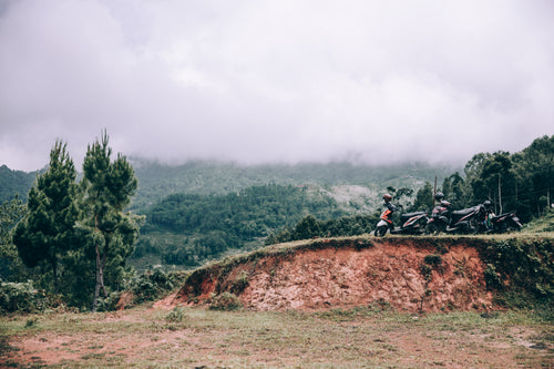 group of touring motorbikes parked along jungle roadway