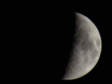 half of the moon against a black night sky