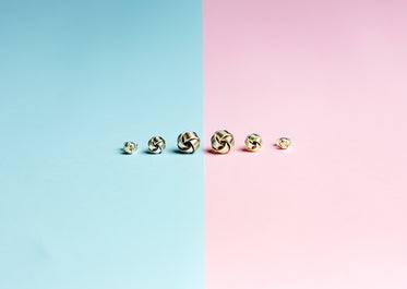 half pink half blue background with stud earrings in a row