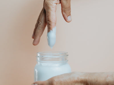 Hand And A Glass Jar Of Hand Cream