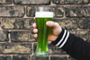 hand holding a green beer celebrating st. patricks day