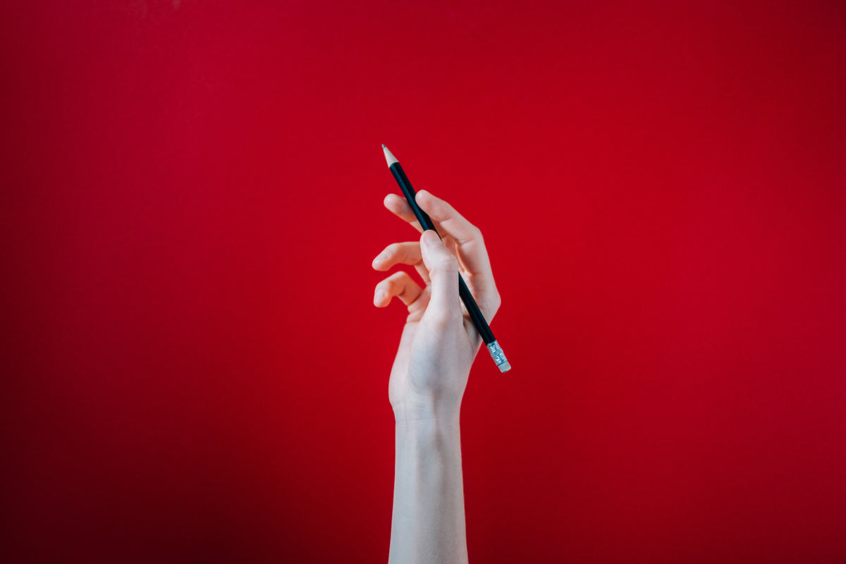 手握红底色黑色铅笔