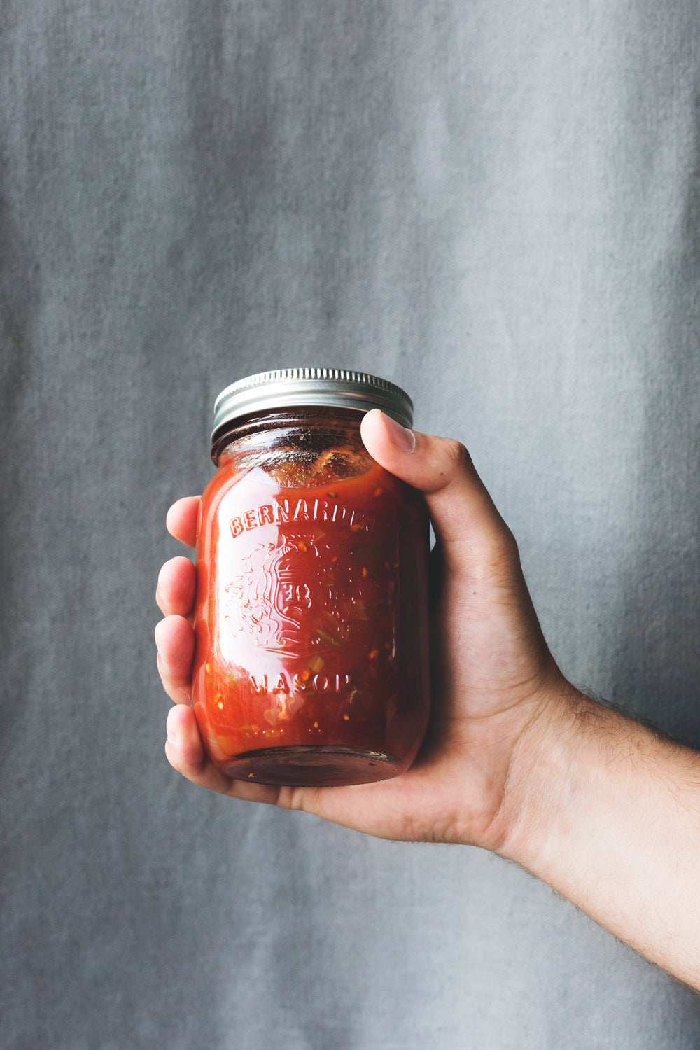 hand holding freshly canned salsa