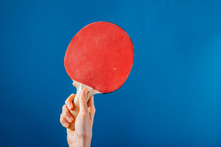 Hand Holding Ping Pong Paddle On Blue Background
