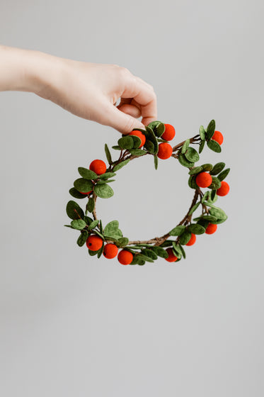 hand holding small festive wreath
