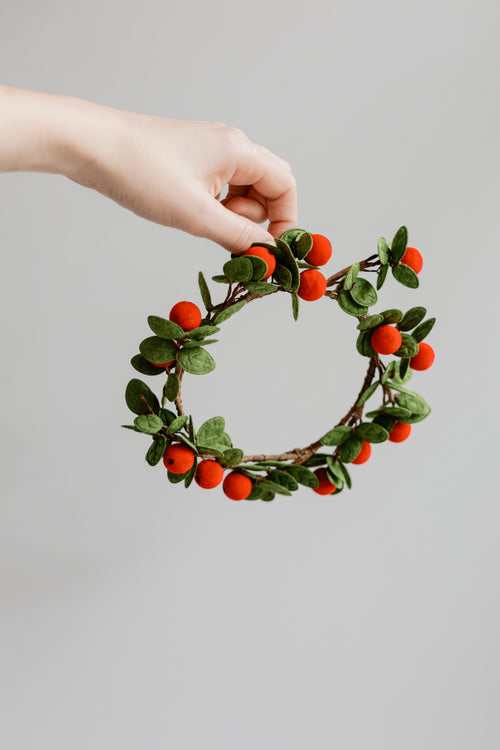 hand holding small festive wreath