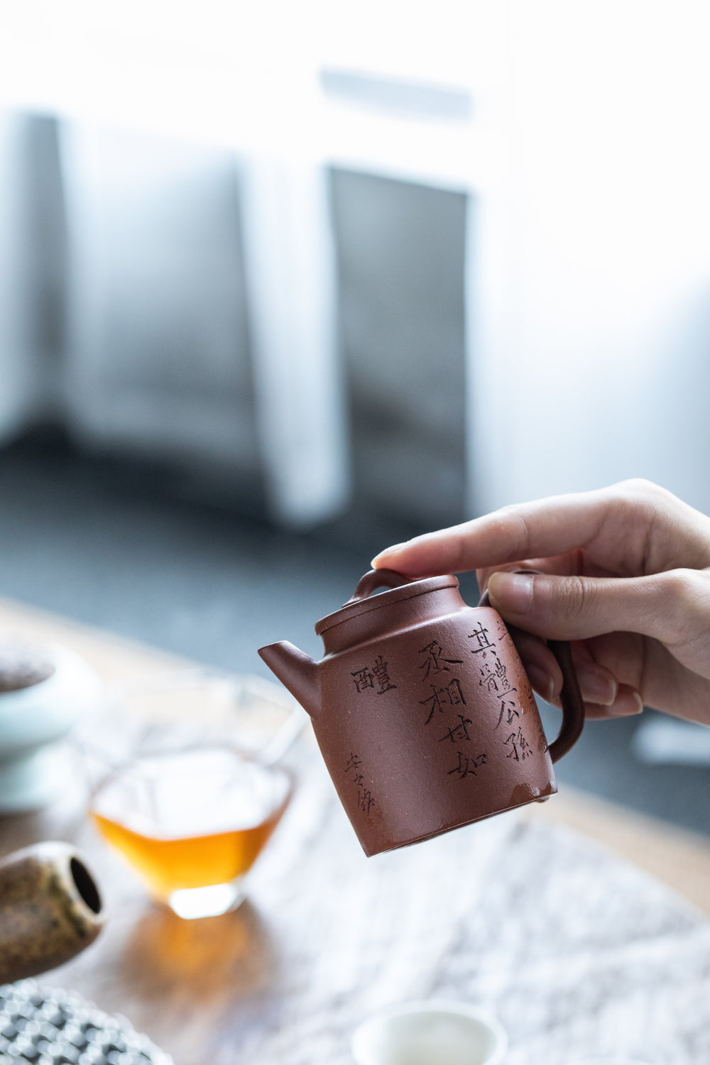 hand holding top of chinese teapot