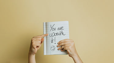 hand holds a book up with lined paper and and written text