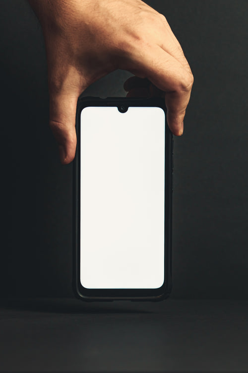 hand holds a cell phone over a black background
