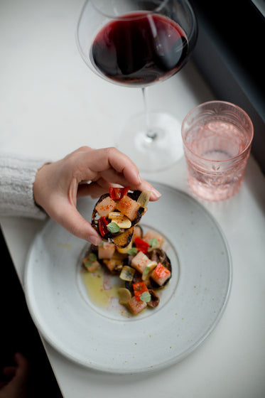 hand holds a crostini appetizer