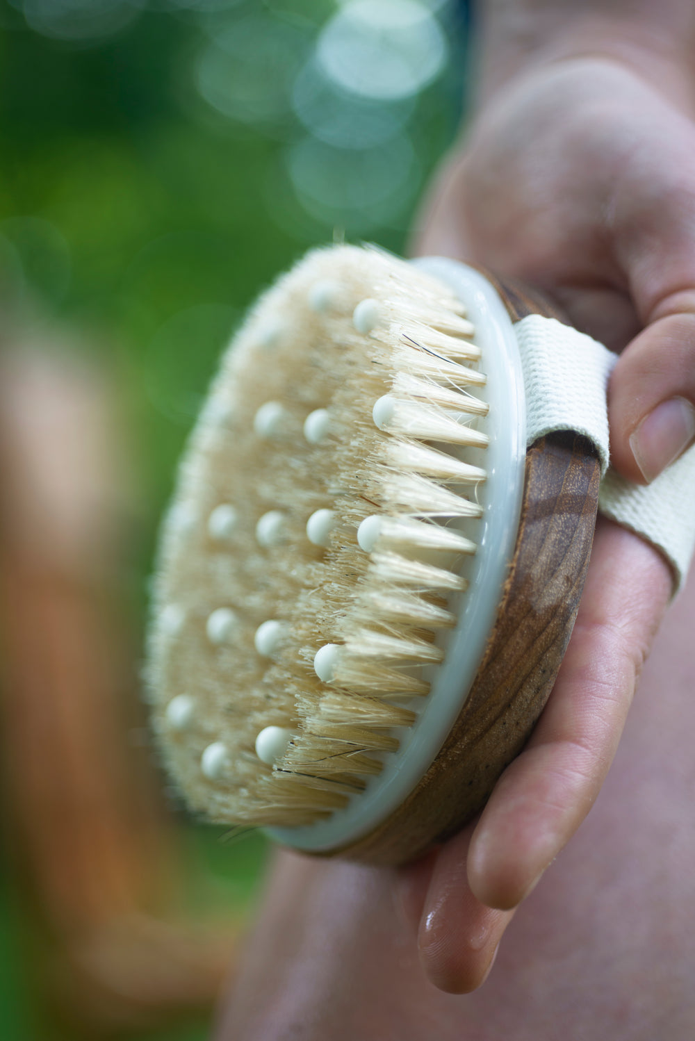 hand holds a skin exfoliator towards the camera