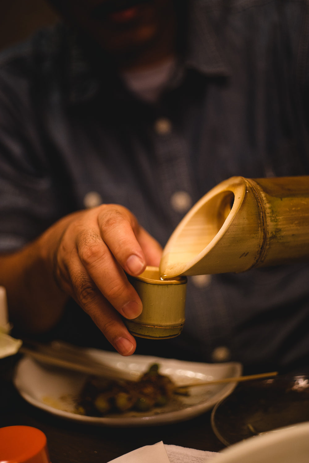 hand holds a small cup and pours water into it