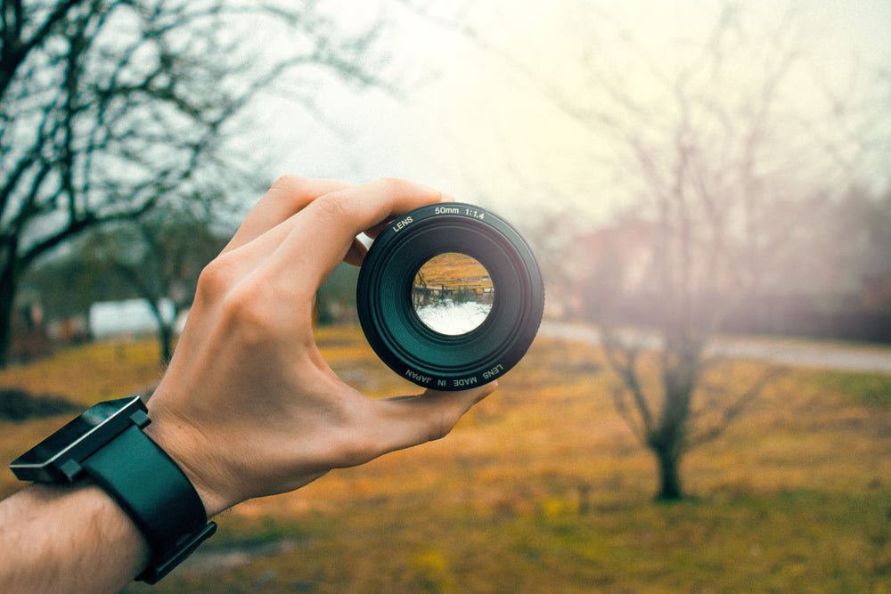 hand holds camera lens