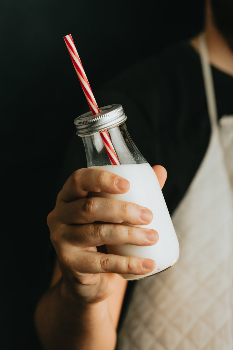 hand-holds-clear-bottle-of-milk-with-a-s