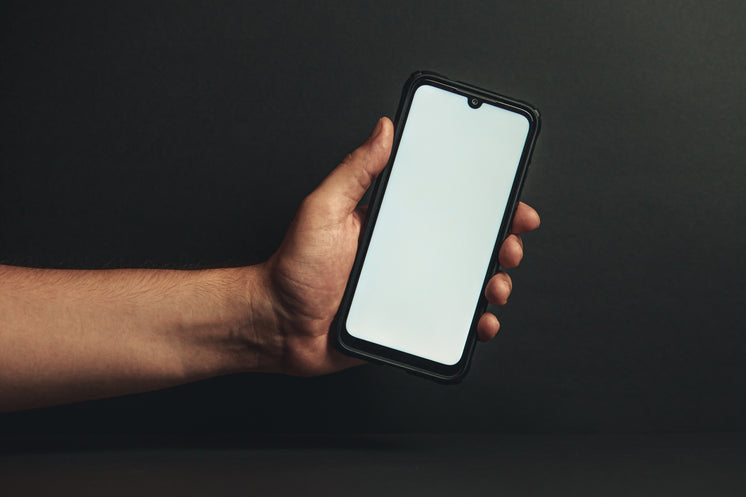 Hand Holds Out Phone Against Black Background