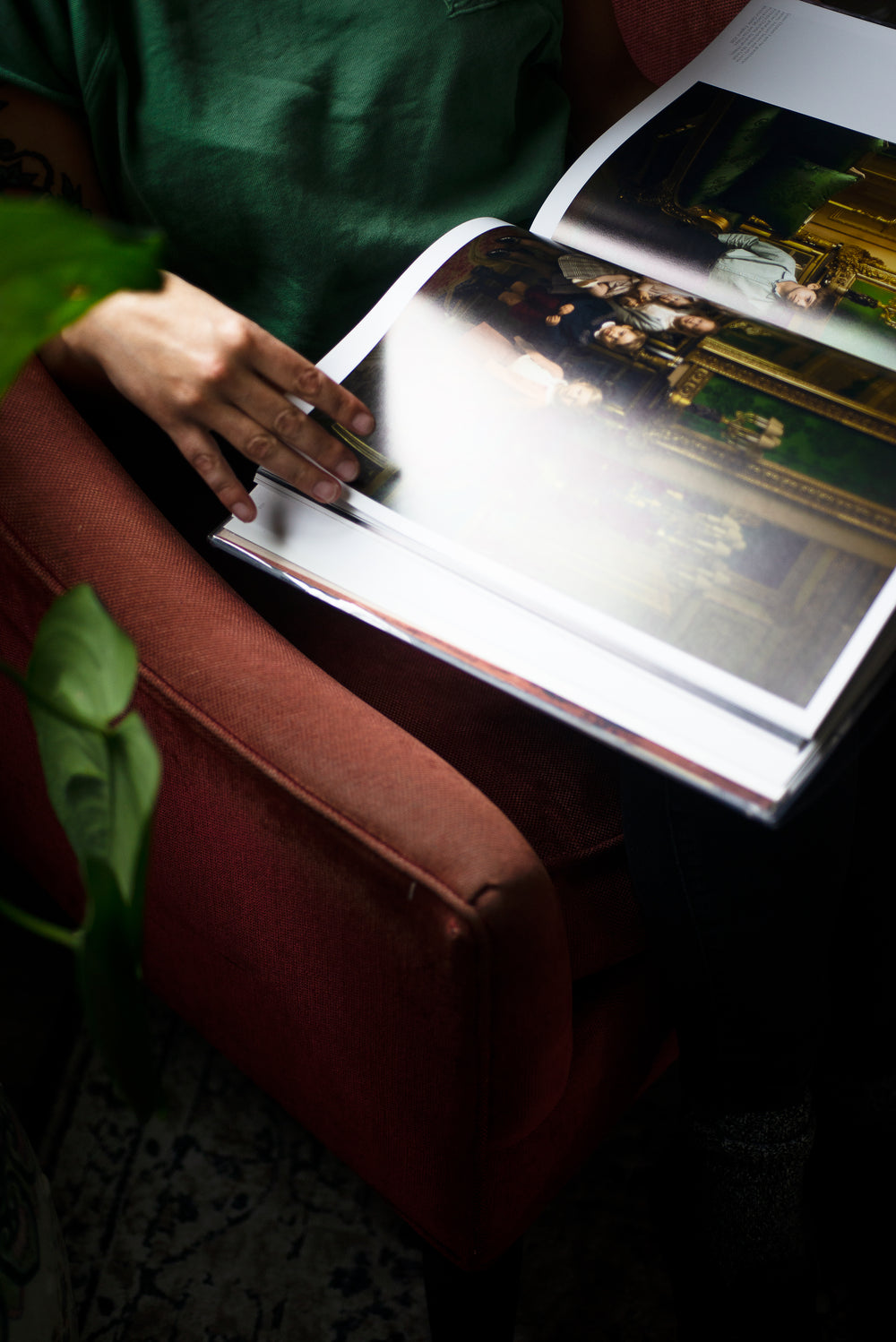  hand holds the bottom corner of a large coffee table book